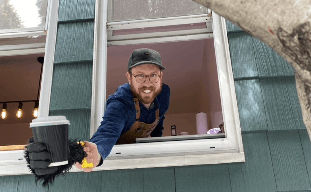 Ben Ramirez with a cup of coffee at his window 